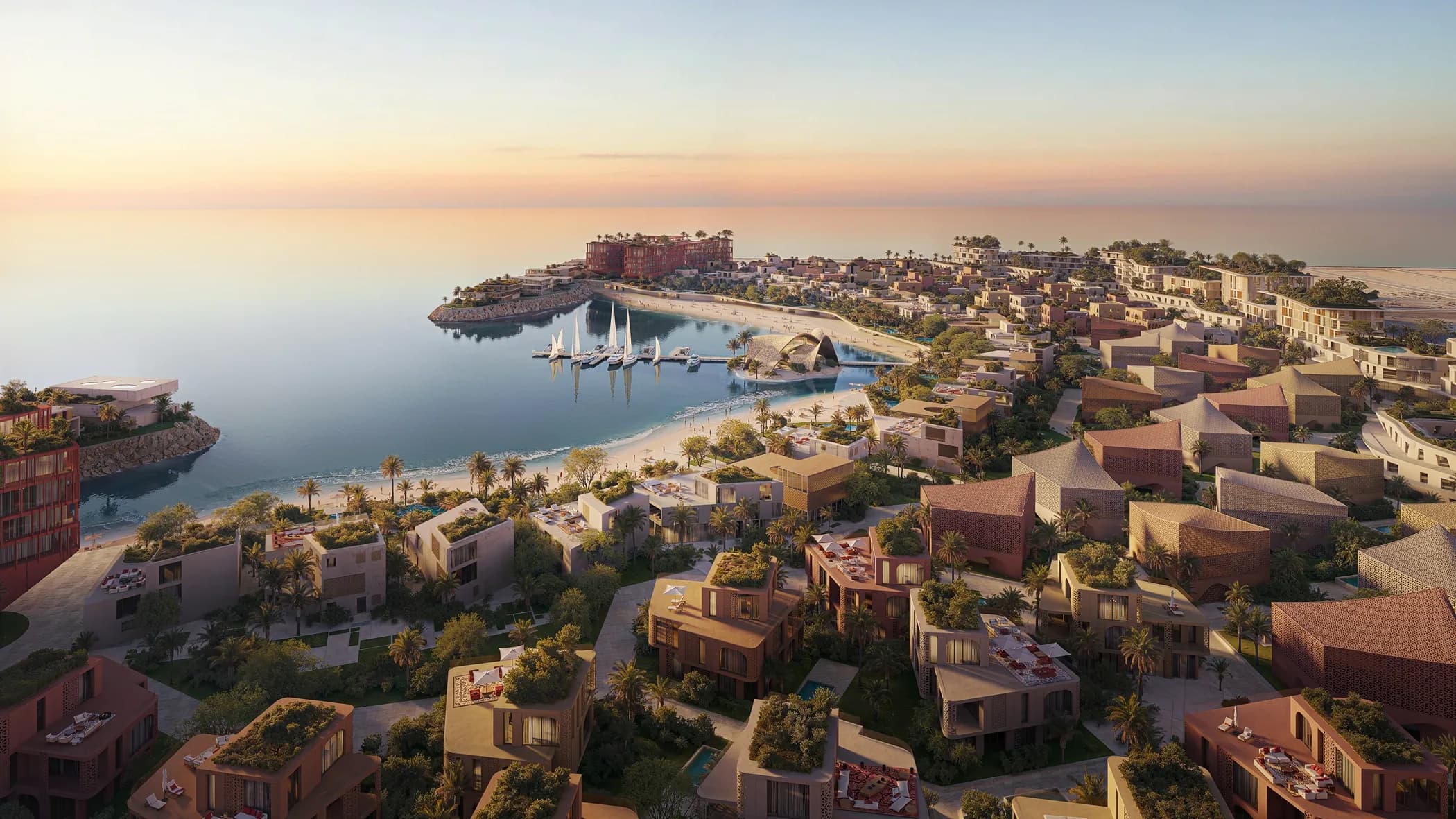 Aerial view of the Mira Coral Bay marina, beaches and low-rise villas at golden hour