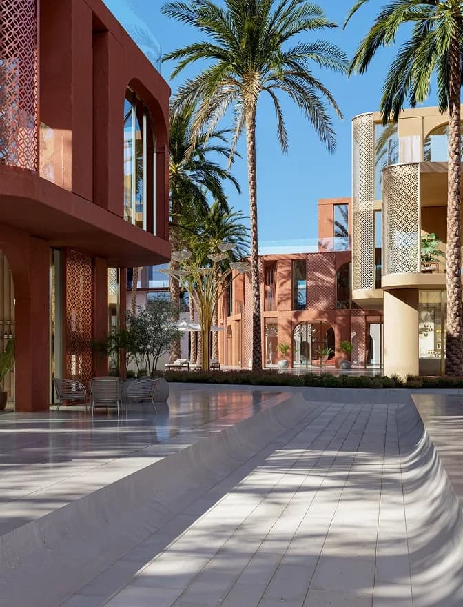 Pedestrian street between terracotta buildings and palms