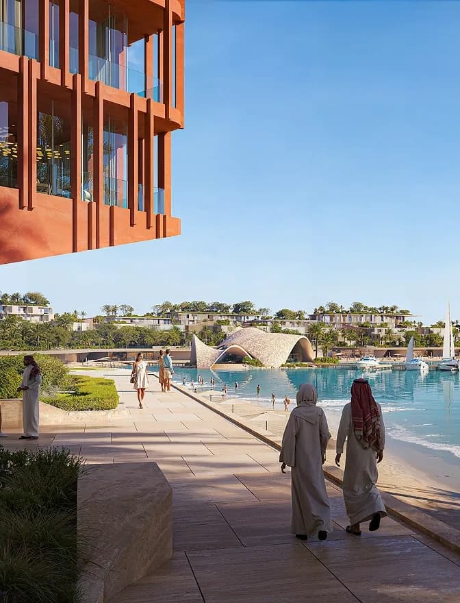 Two residents walking along the lagoon promenade toward the hotels